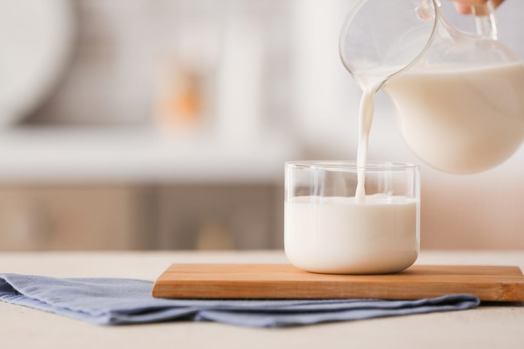 Pouring,Of,Milk,Into,Glass,On,Table
